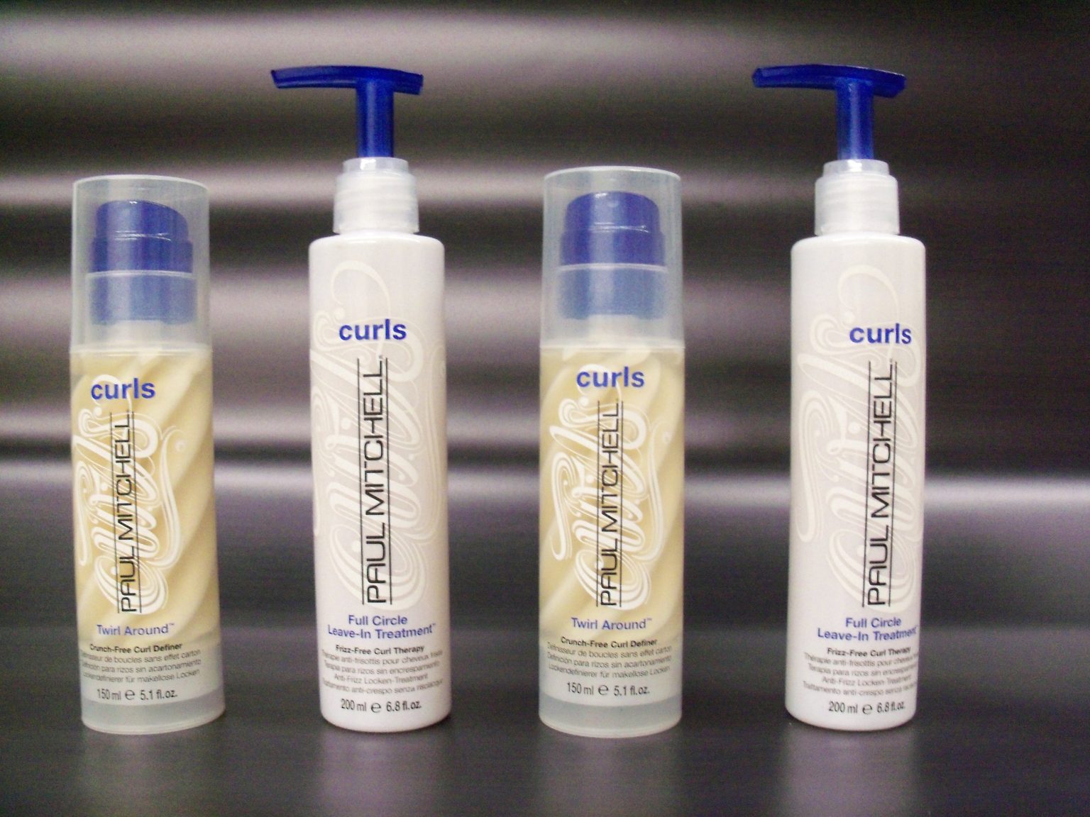 Paul Mitchell Curls shampoo and conditioner bottles displayed together, showcasing their vibrant packaging and branding with custom rub on transfer designs on the bottles.